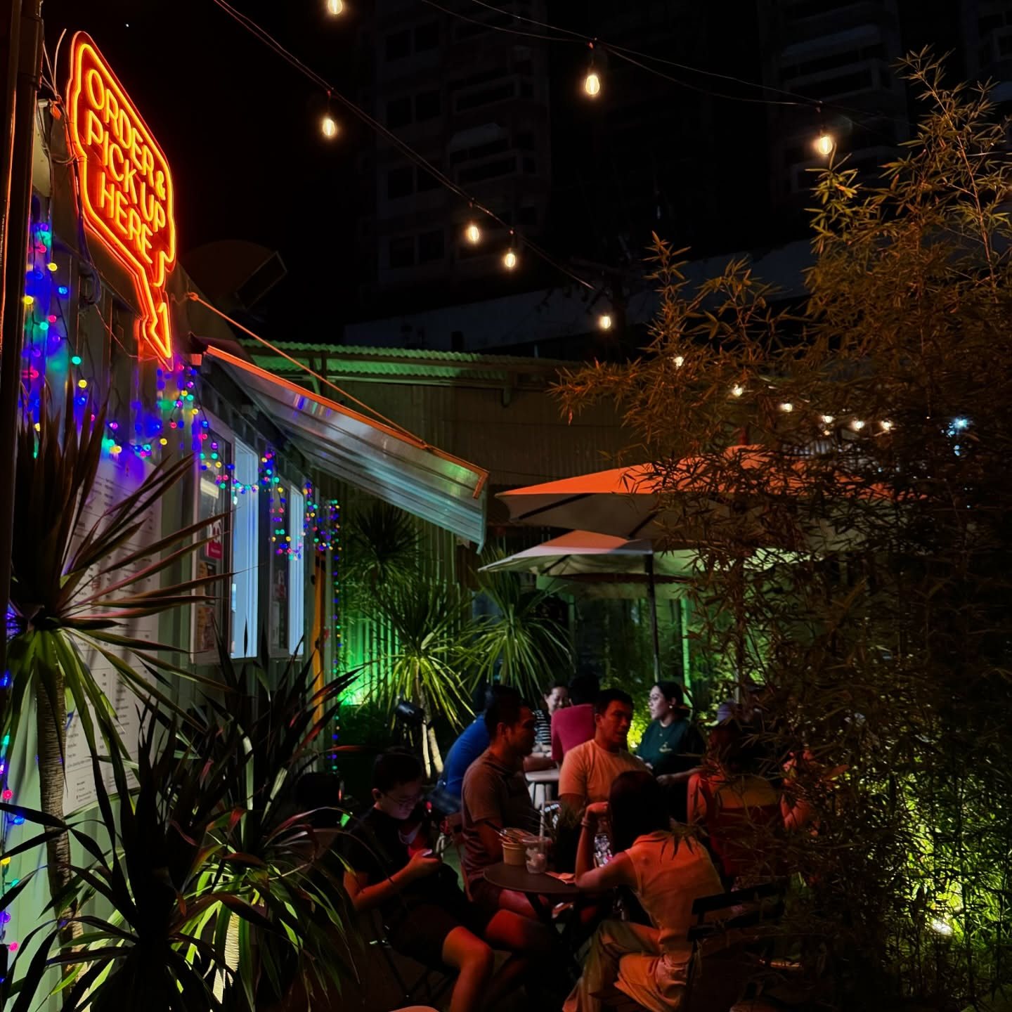 Guests eating at Kinn Kinn in the evening under string lights